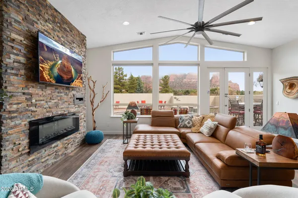 a living room with furniture kitchen view and a chandelier
