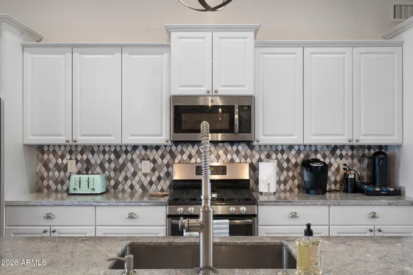 a bedroom with a bed and a flat tv screen on dresser