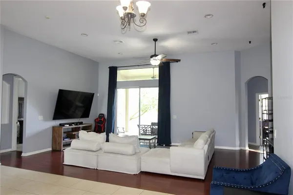 a living room with furniture a chandelier and a flat screen tv