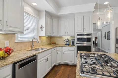 a kitchen with a sink a stove and chairs