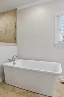 a bedroom with a bed a dresser and chair