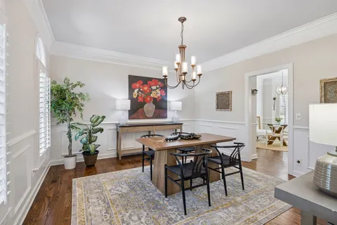 a view of a dining room and livingroom with furniture wooden floor a chandelier