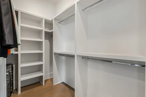 a view of walk in closet with empty racks