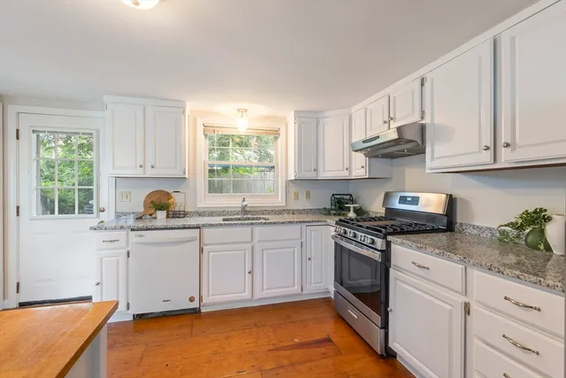a kitchen with granite countertop white cabinets and white appliances