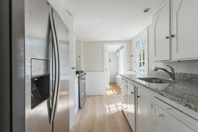 a kitchen with stainless steel appliances granite countertop a refrigerator and a sink