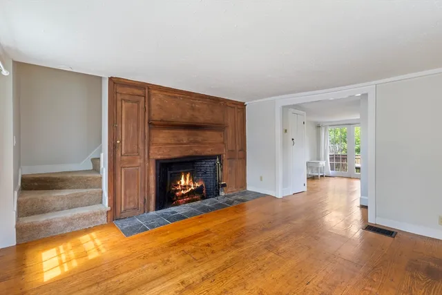 a view of empty room with wooden floor and fireplace
