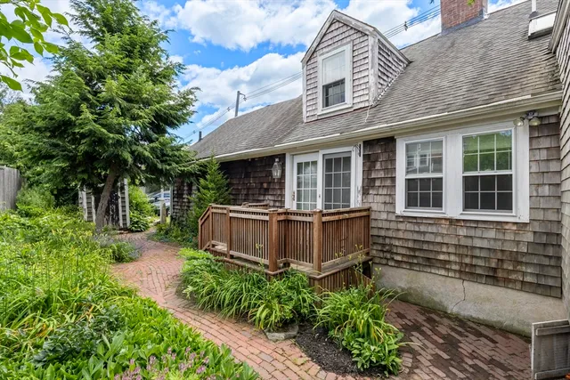 a front view of a house with a yard and potted plants