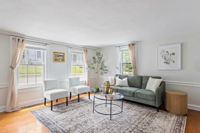a living room with furniture and a window with wooden floor