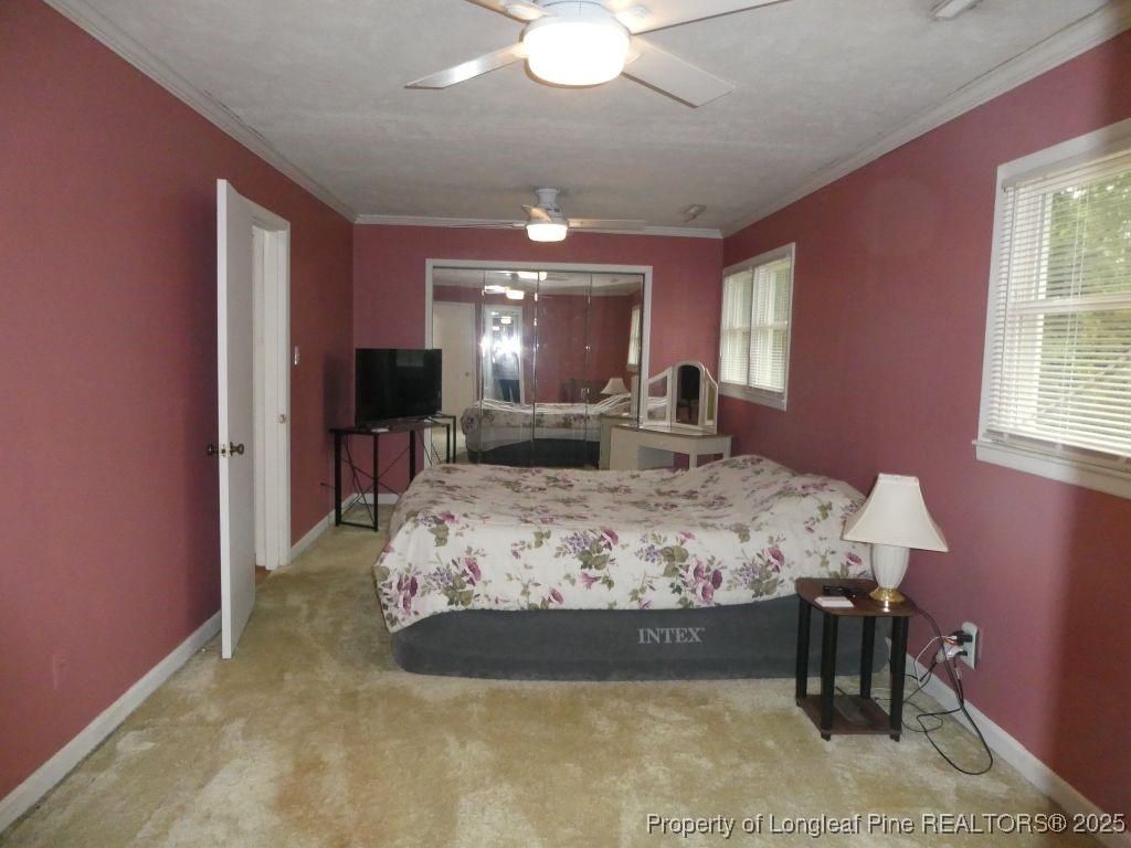 263 Forest Road Lumberton, NC 28358 - Photo 12 of 44 a bedroom with a large bed and a chandelier
