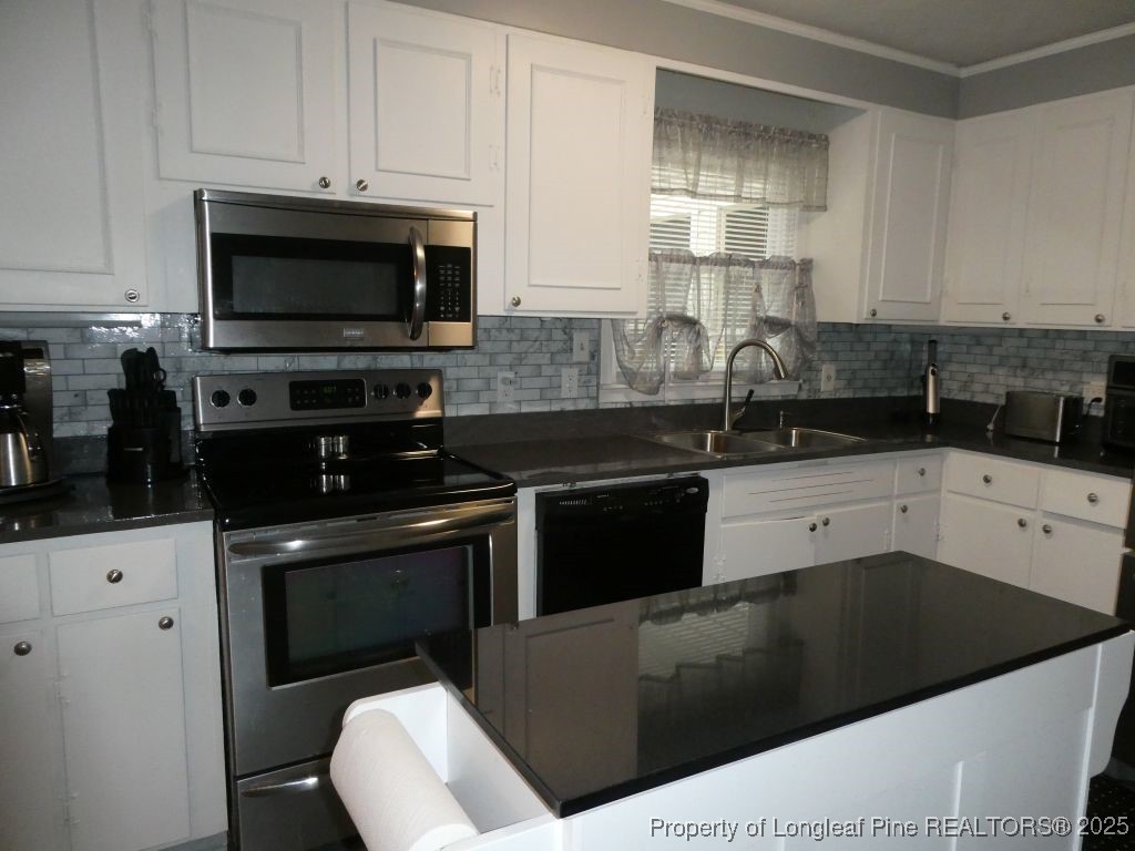 263 Forest Road Lumberton, NC 28358 - Photo 8 of 44 a kitchen with a sink and a stove top oven