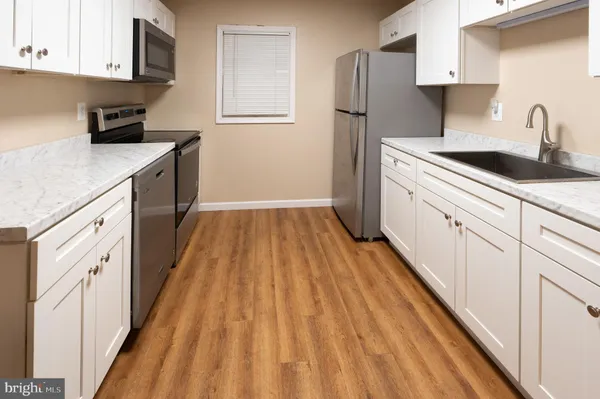 a kitchen with a sink a refrigerator and cabinets