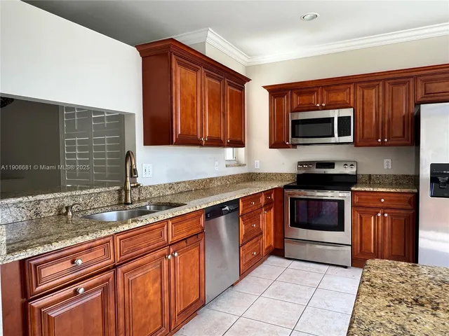a kitchen with stainless steel appliances granite countertop a sink stove and microwave