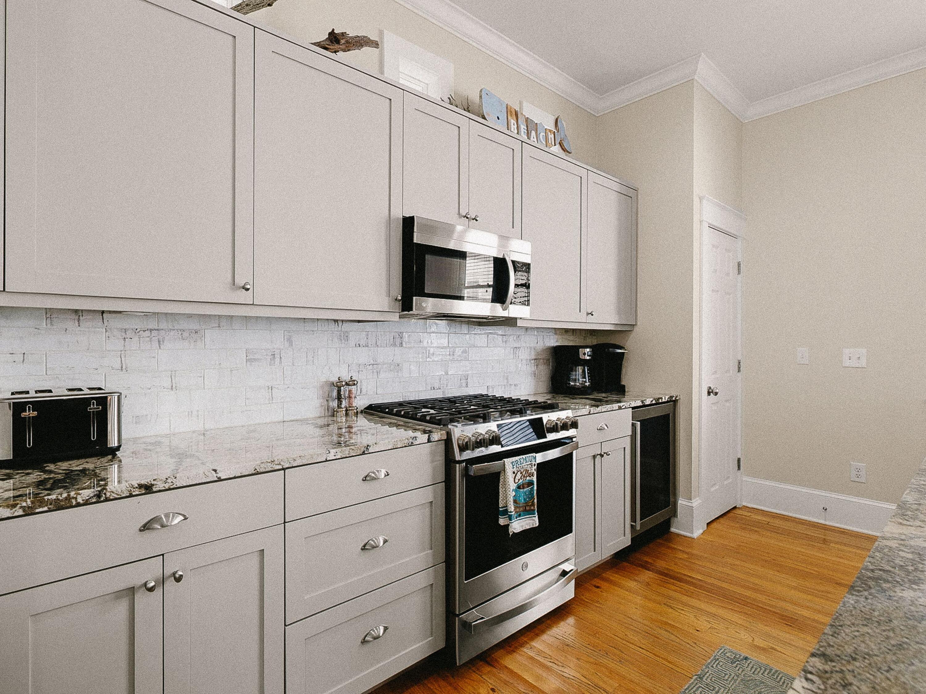 107 Chelsea Loop Road Santa Rosa Beach, FL 32459 - Photo 11 of 28 a kitchen with stainless steel appliances granite countertop a stove a microwave and white cabinets