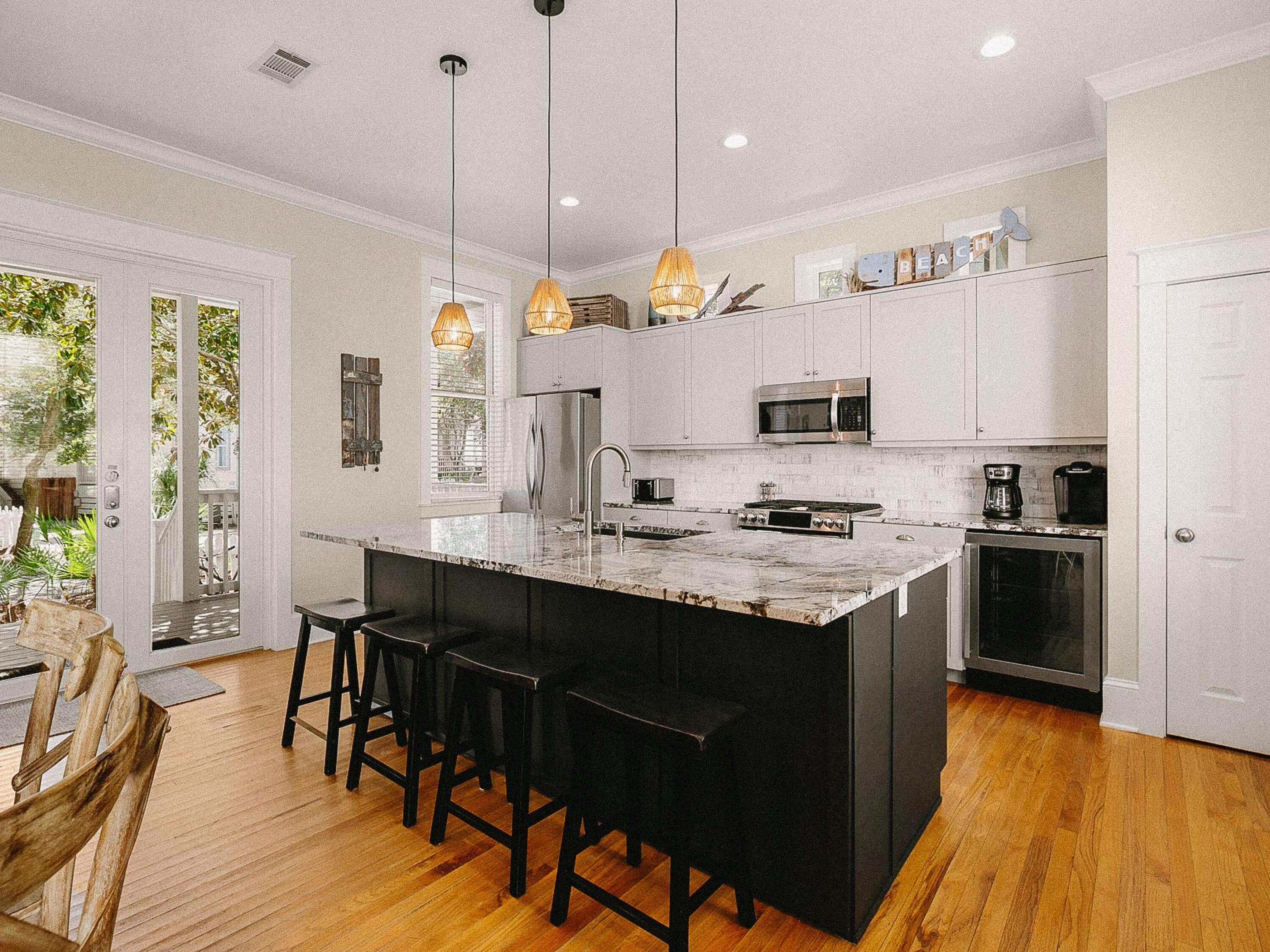107 Chelsea Loop Road Santa Rosa Beach, FL 32459 - Photo 4 of 28 a kitchen with stainless steel appliances granite countertop a sink a stove a refrigerator and island with wooden floor