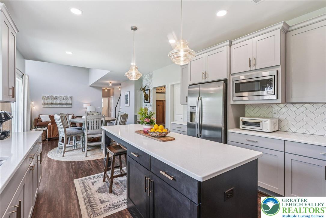 3334 Coventry Drive Lower Macungie Township, PA 18062 - Photo 23 of 51 a kitchen with stainless steel appliances granite countertop a table chairs stove and microwave