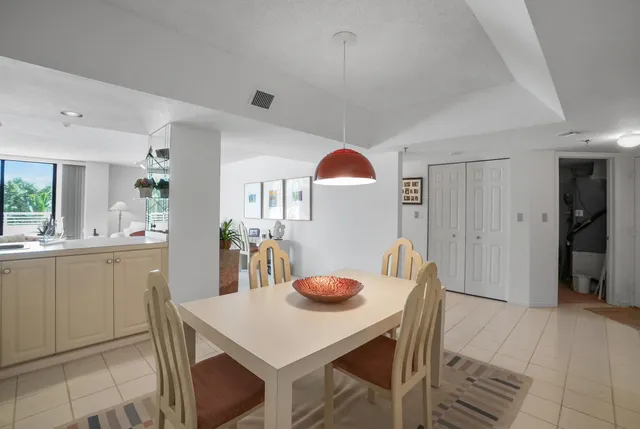a kitchen with stainless steel appliances granite countertop a table chairs and a refrigerator