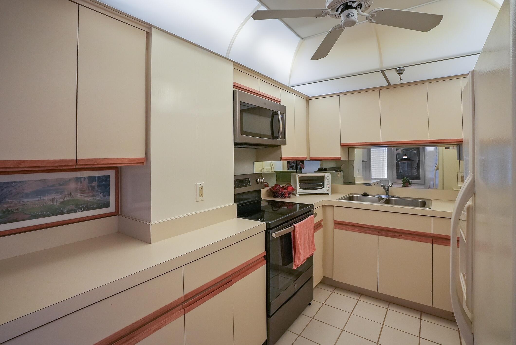 176 Helios Drive, Unit 102 Jupiter, FL 33477 - Photo 15 of 25 a kitchen with stainless steel appliances granite countertop a sink and cabinets
