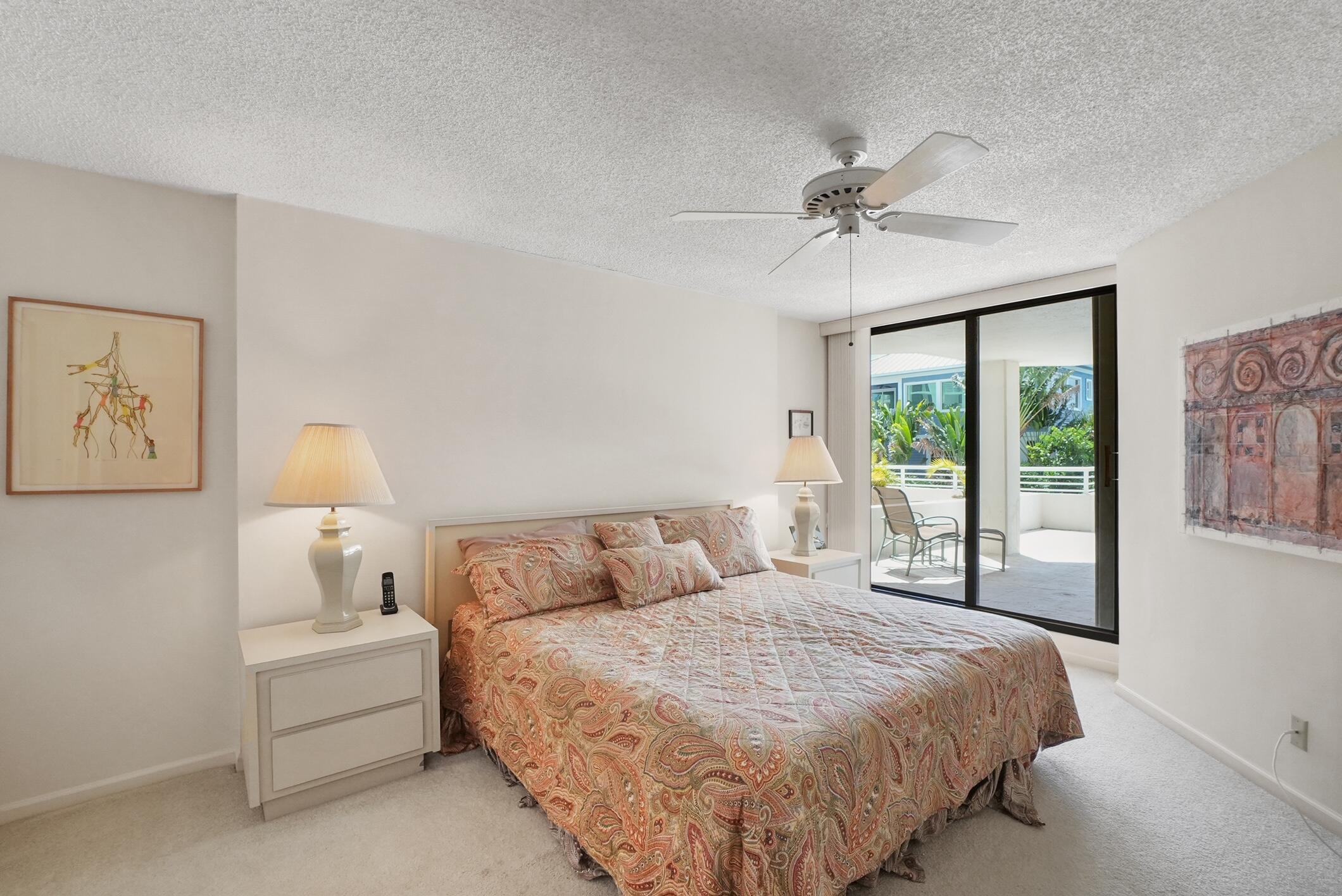 176 Helios Drive, Unit 102 Jupiter, FL 33477 - Photo 20 of 25 a bedroom with a large bed and a window