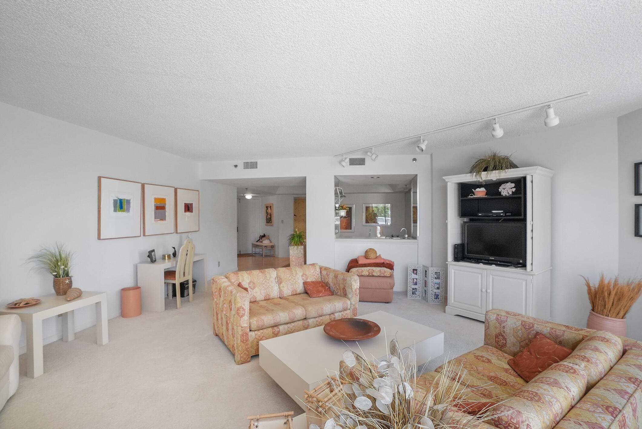 176 Helios Drive, Unit 102 Jupiter, FL 33477 - Photo 6 of 25 a living room with furniture and a flat screen tv