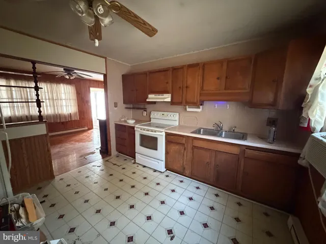 a kitchen with a sink a stove cabinets and counter space