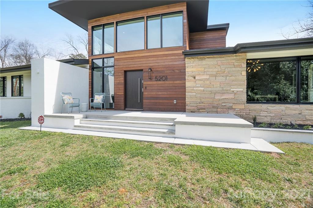 a view of a house with a large window and a yard