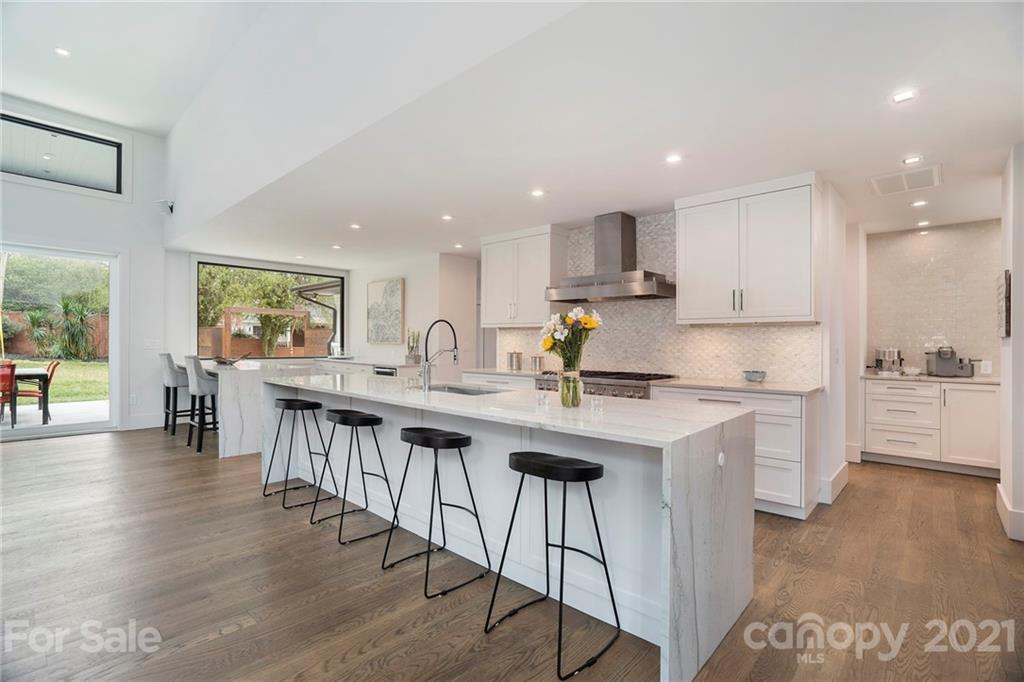 5201 Addison Drive Charlotte, NC 28211 - Photo 15 of 48 a kitchen with stainless steel appliances granite countertop a stove a sink a refrigerator and white cabinets with wooden floor