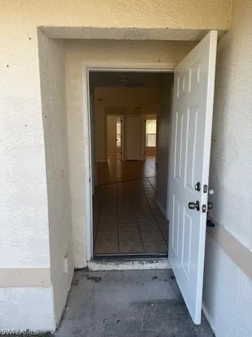 an empty room with wooden floor and a bench