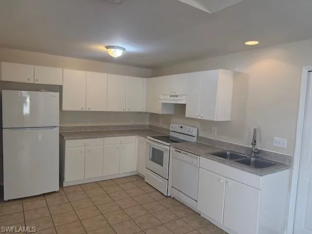 a kitchen with white cabinets sink and white appliances