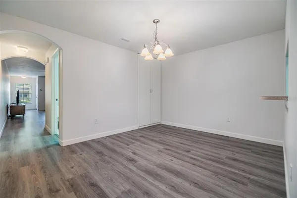 a view of a hallway with wooden floor and a chandelier