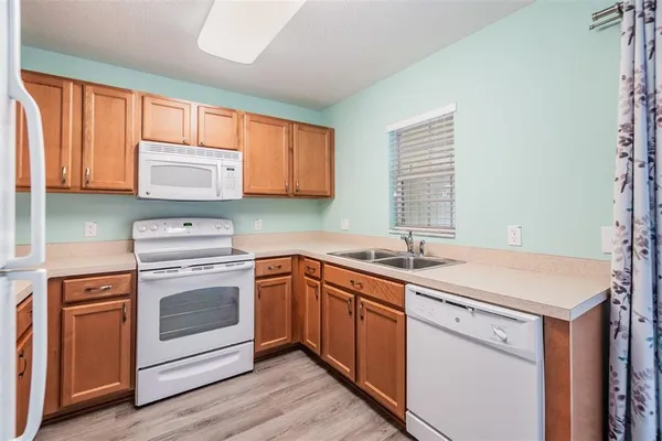 a kitchen with stainless steel appliances granite countertop wooden cabinets sink and window