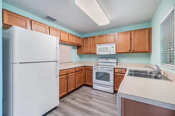 a kitchen with stainless steel appliances granite countertop a refrigerator sink stove and cabinets