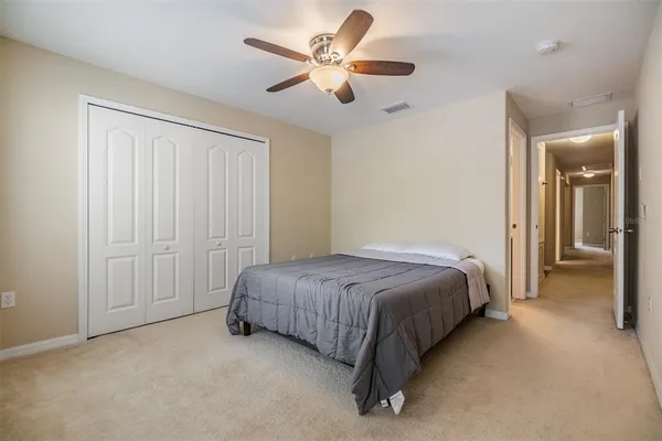 a spacious bedroom with a bed and a ceiling fan