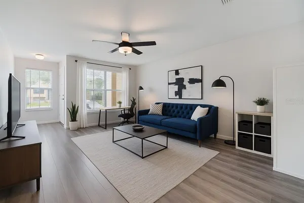 a living room with furniture a ceiling fan and a rug