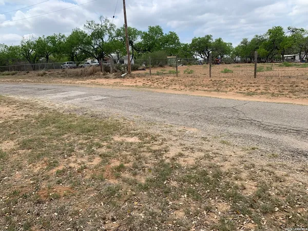 a view of a yard with wooden fence