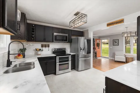 a kitchen with stainless steel appliances granite countertop a refrigerator stove top oven and sink