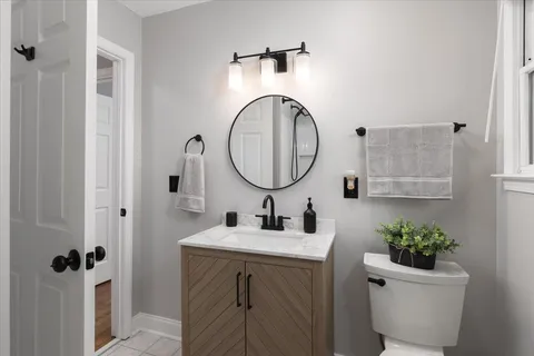 a bathroom with a toilet a sink and a mirror