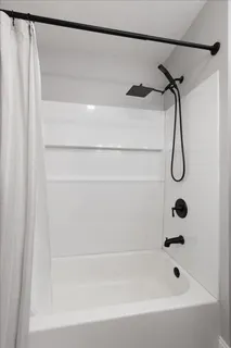 a bathroom with a shower and a bath tub