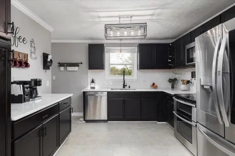 a kitchen with stainless steel appliances granite countertop a sink stove and refrigerator