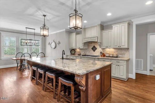 a kitchen with kitchen island granite countertop a stove a sink and a refrigerator