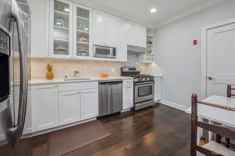 a kitchen with cabinets stainless steel appliances and wooden floor