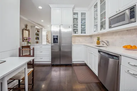 a kitchen with stainless steel appliances a refrigerator and wooden floor
