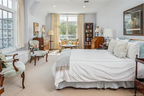 a bedroom with a bed and large windows