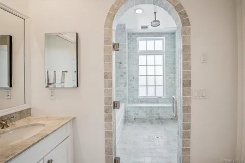 a bathroom with a granite countertop sink a mirror and a shower