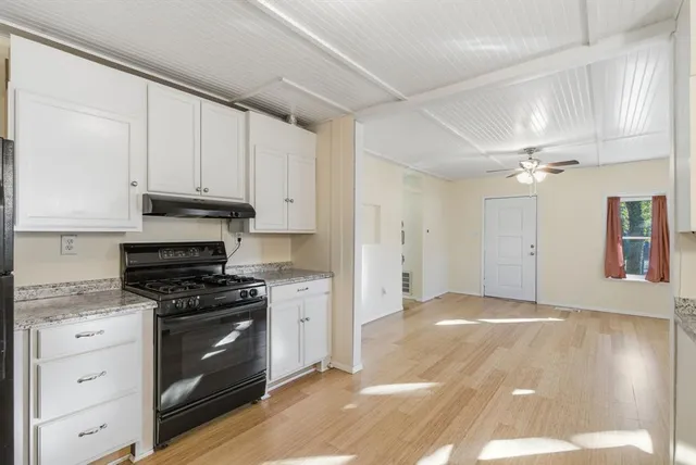 a kitchen with granite countertop a stove a sink and a refrigerator