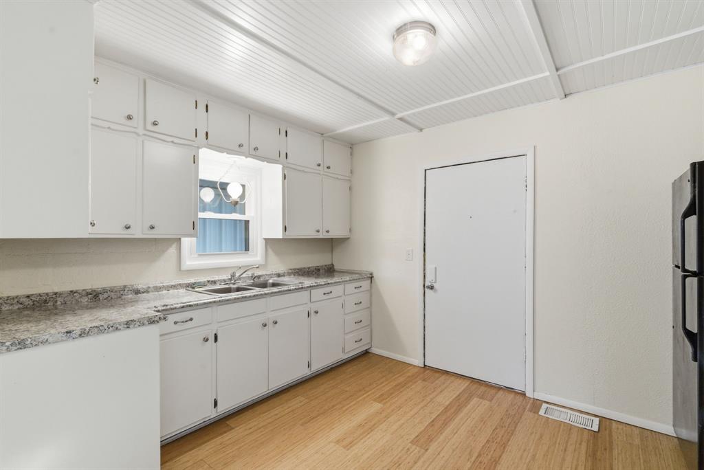 917 Carpenter Street Azle, TX 76020 - Photo 5 of 40 a kitchen with a sink a window and cabinets
