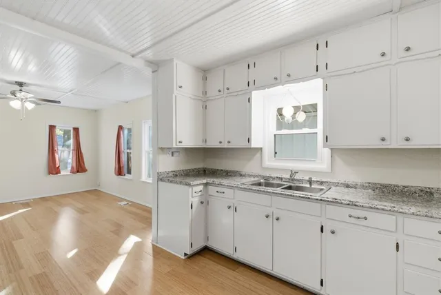 a kitchen with granite countertop white cabinets and white appliances