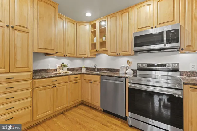 a kitchen with stainless steel appliances granite countertop a stove a sink and a microwave