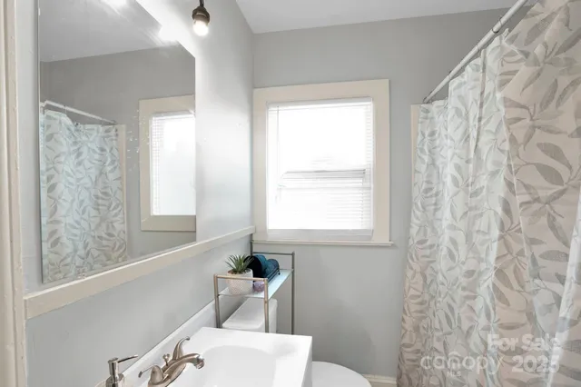 a bathroom with a bathtub a window and a shower