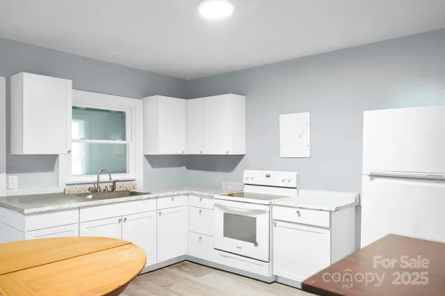 a kitchen with white cabinets and white appliances