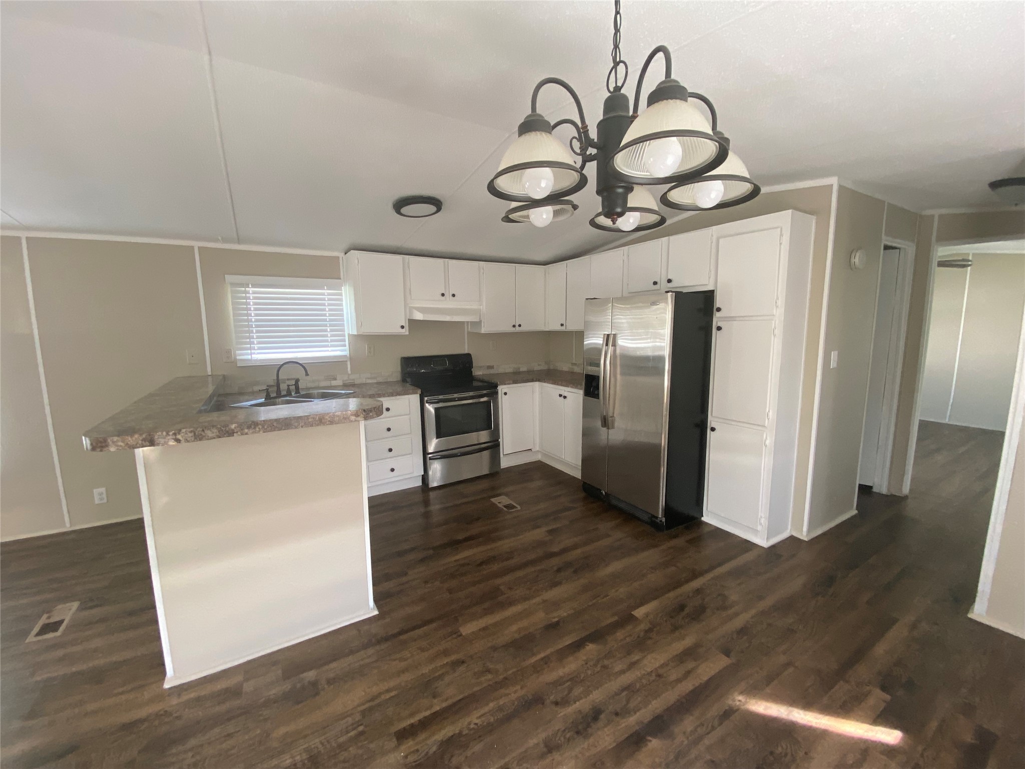 2021 North Battlebell Road, Unit 28 Highlands, TX 77562 - Photo 6 of 8 a kitchen with stainless steel appliances granite countertop a white cabinets and wooden floor